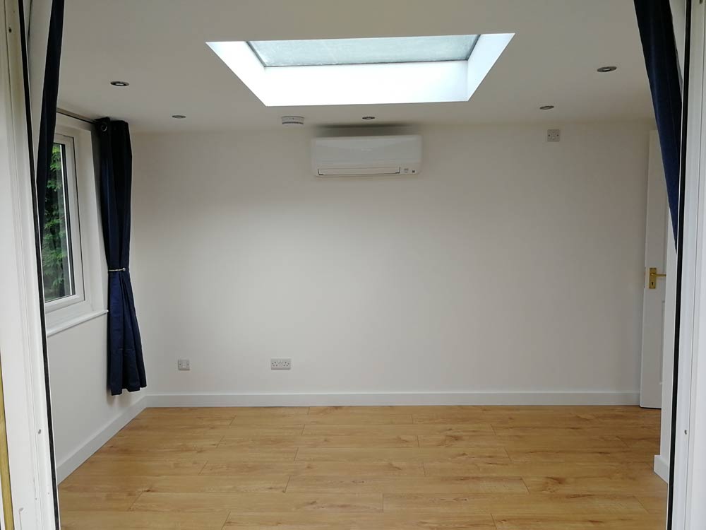 Heated garden office, showing wall mounted heating unit / heat pump and air conditioning unit