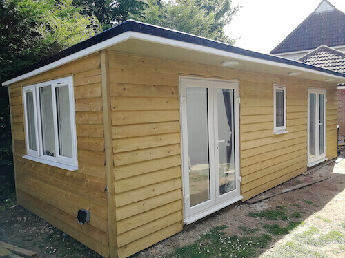 The exterior of a finished, multi-room log cabin style office.